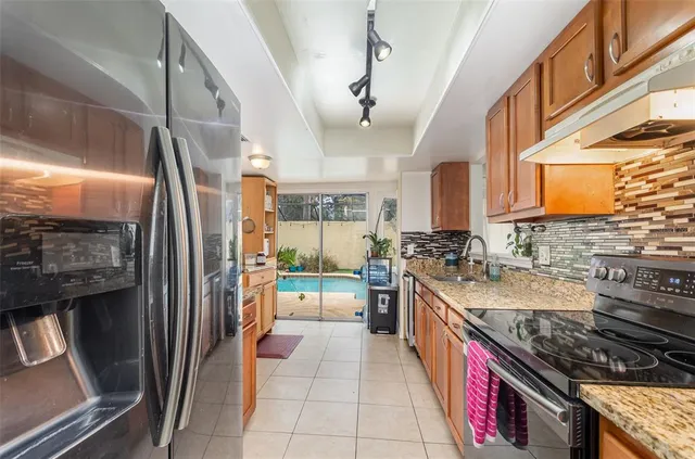 a kitchen with stainless steel appliances granite countertop a stove and a refrigerator