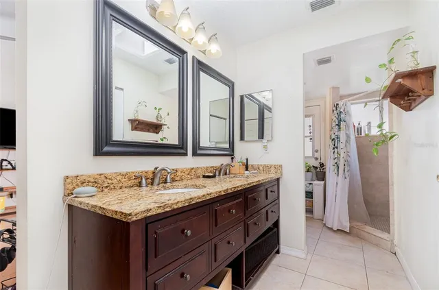 a bathroom with a granite countertop sink and a mirror