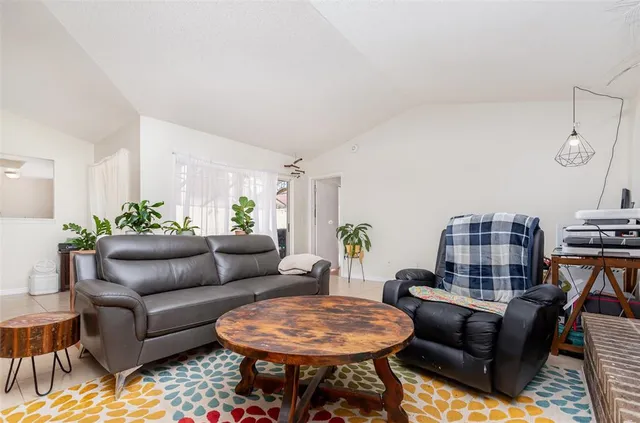 a living room with furniture a rug and a table
