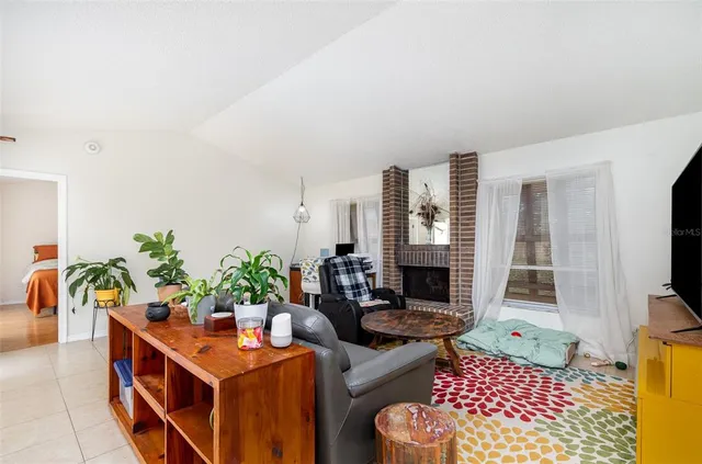 a living room with furniture a flat screen tv and a potted plant