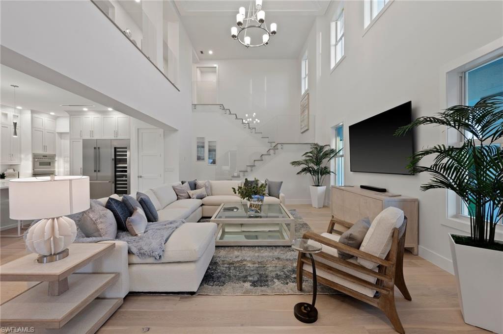 a living room with furniture a chandelier and a flat screen tv