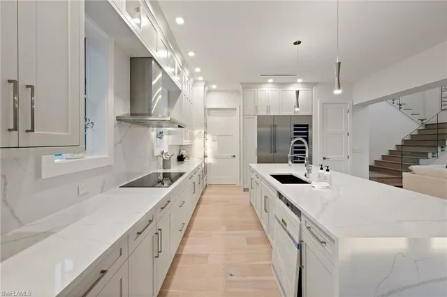 a large white kitchen with stainless steel appliances