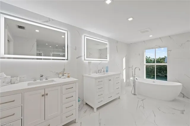 a bathroom with a granite countertop sink mirror and window