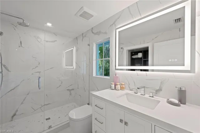 a bathroom with a sink a toilet and shower