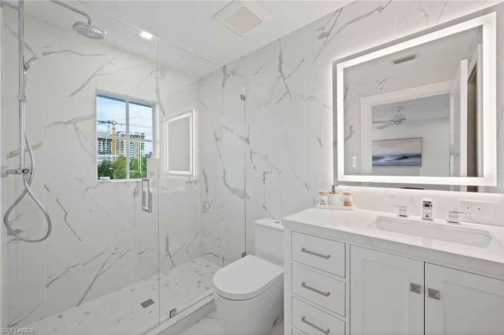1984 Frederick Street Naples, FL 34112 - Photo 25 of 38 a bathroom with a shower sink vanity mirror and toilet