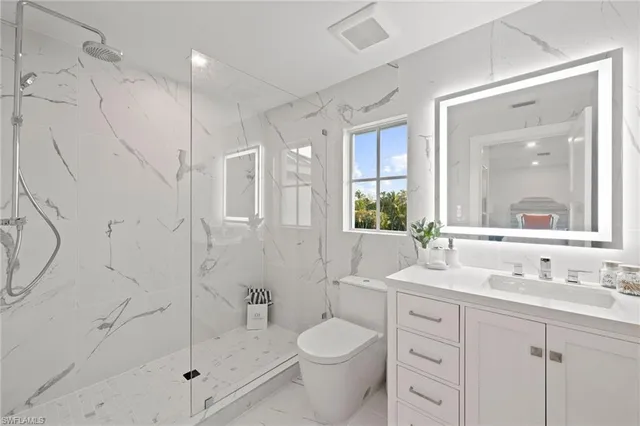 a bathroom with a granite countertop sink toilet and shower