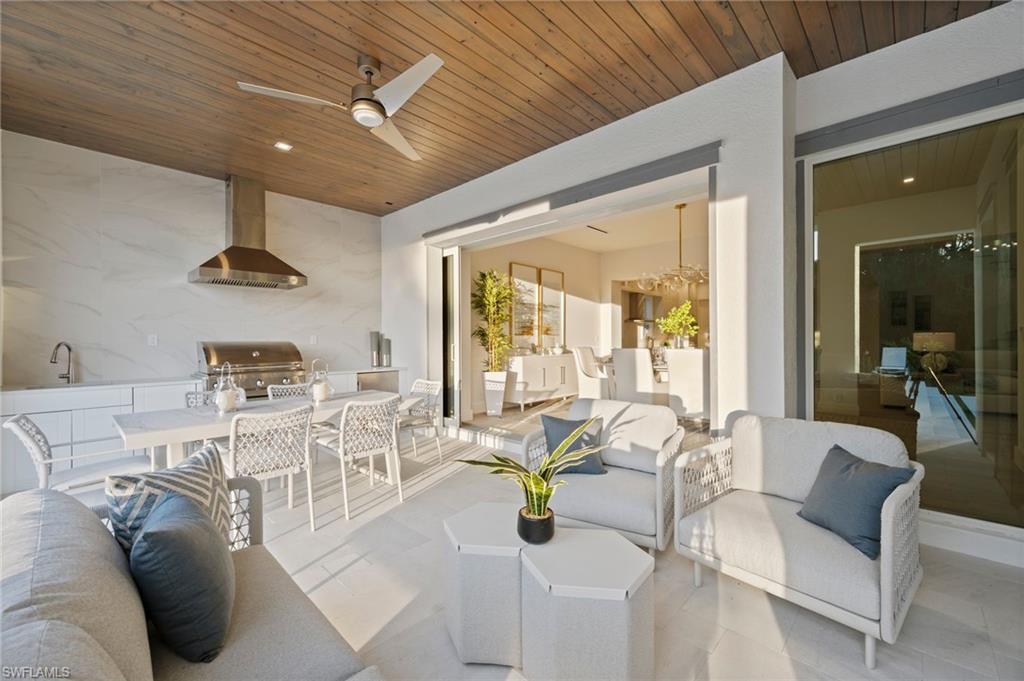 1984 Frederick Street Naples, FL 34112 - Photo 30 of 38 a view of a dining room with furniture wooden floor and a chandelier