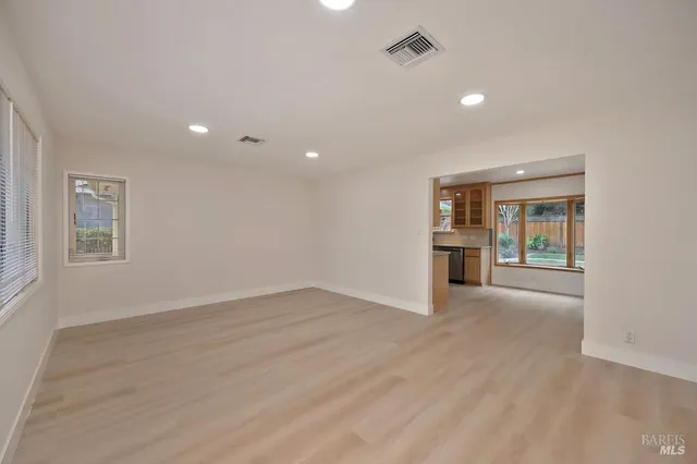 a view of empty room with wooden floor and fireplace