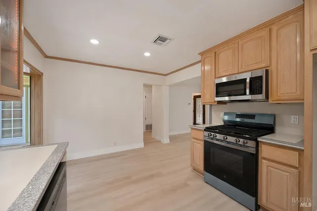 a large kitchen with stainless steel appliances granite countertop a stove and a refrigerator