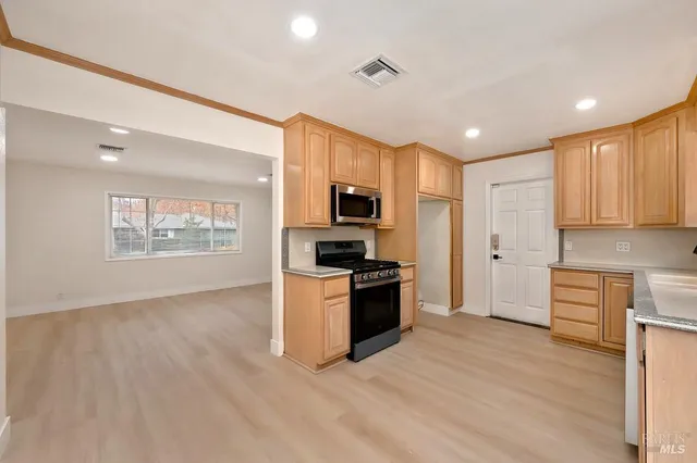 a kitchen with cabinets and wooden floor