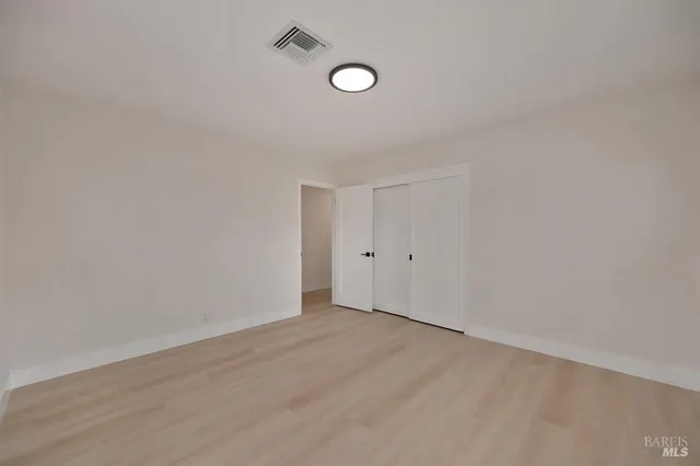 a view of a hallway with wooden floor and windows