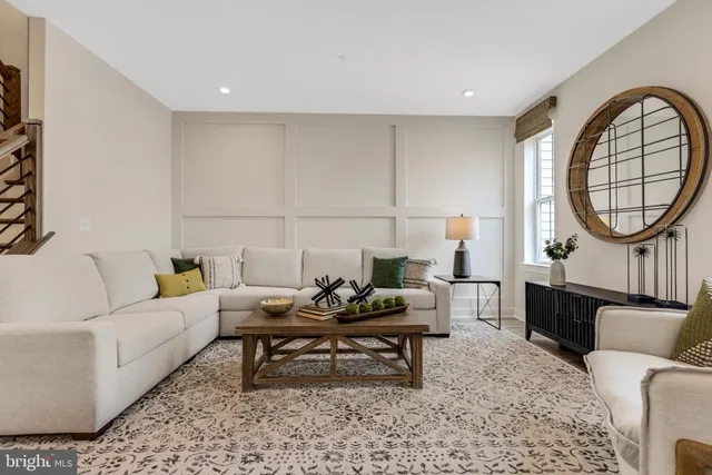 a living room with furniture a rug a lamp and a large window