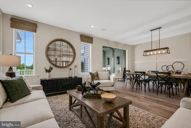 a living room with furniture a large window and a chandelier