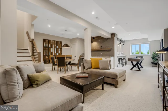 a living room with furniture and a view of kitchen