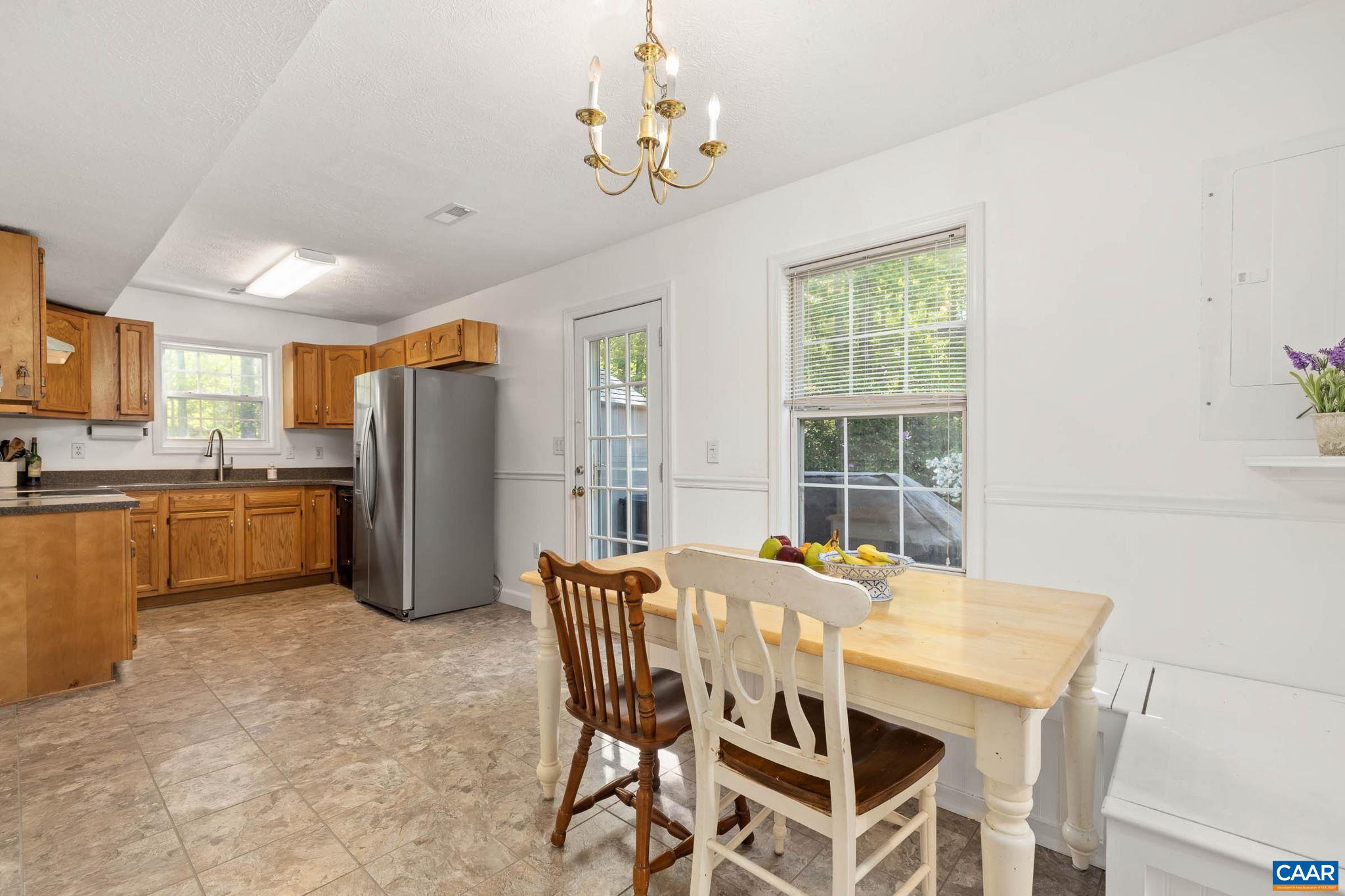 326 Geranium Road Ruckersville, VA 22968 - Photo 21 of 48 a dining room with furniture a chandelier and kitchen view