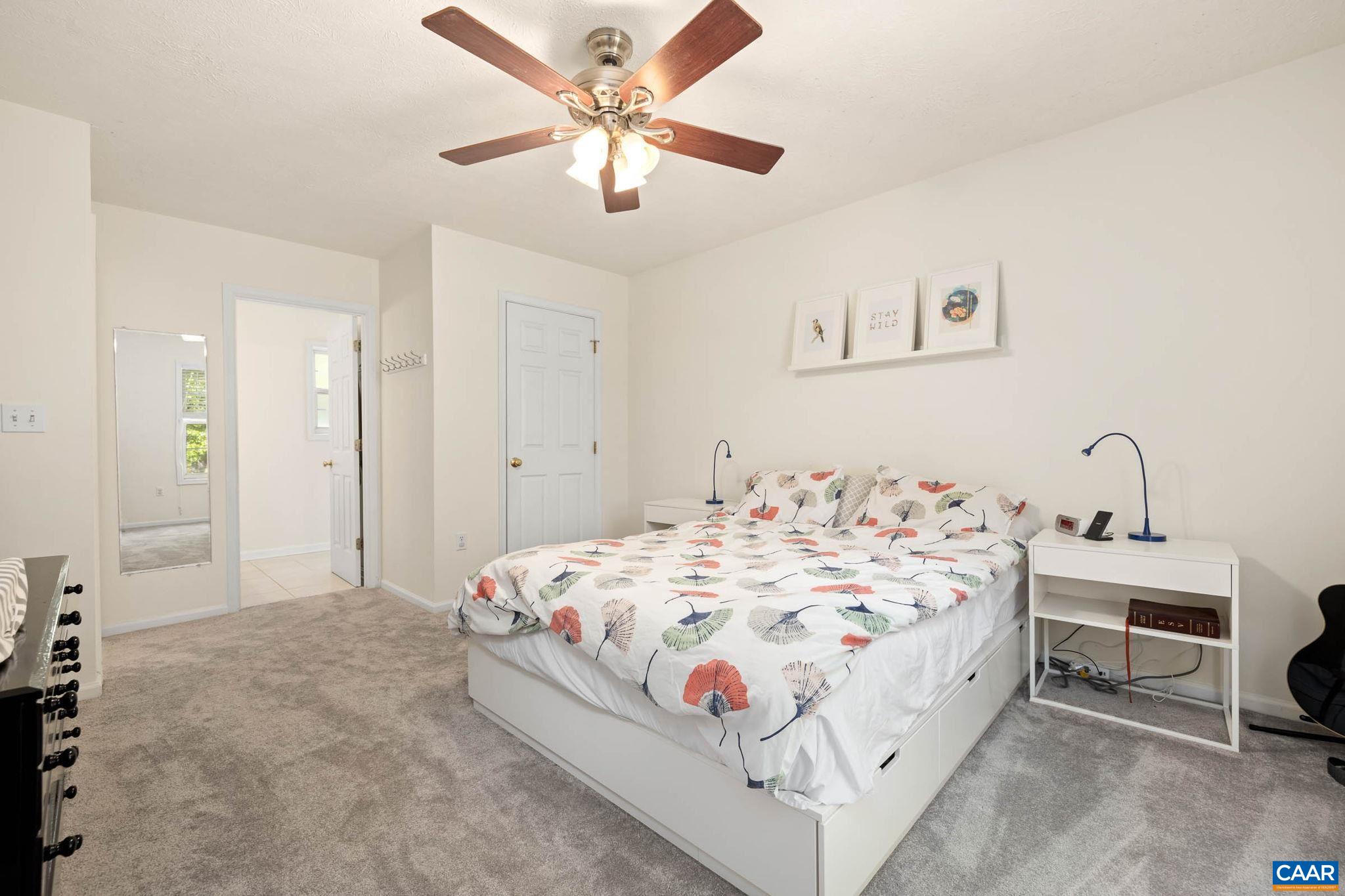 326 Geranium Road Ruckersville, VA 22968 - Photo 34 of 48 a bedroom with a bed and a chandelier