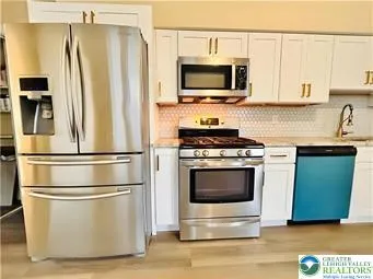 a kitchen with stainless steel appliances a refrigerator stove and microwave