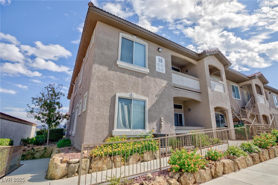 2305 West Horizon Ridge Parkway, Unit 1822 Henderson, NV 89052 - Photo 4 of 34 Rear view of house with a tile roof, a balcony, and stucco siding