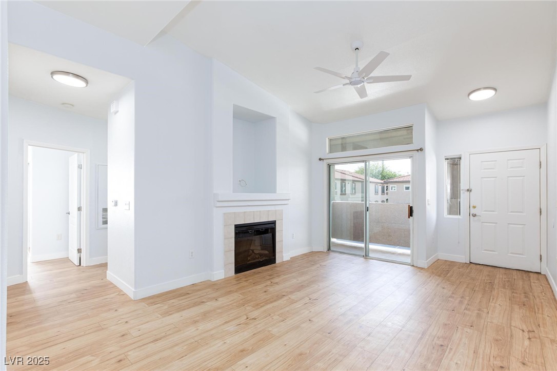 2305 West Horizon Ridge Parkway, Unit 1822 Henderson, NV 89052 - Photo 7 of 34 Unfurnished living room with light wood-type flooring, a fireplace, and a ceiling fan