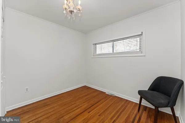 a view of a room with wooden floor a chandelier fan and windows