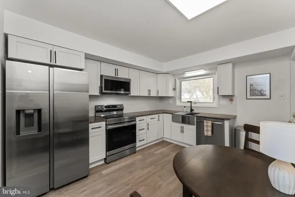 a kitchen with stainless steel appliances granite countertop a refrigerator a stove microwave and sink