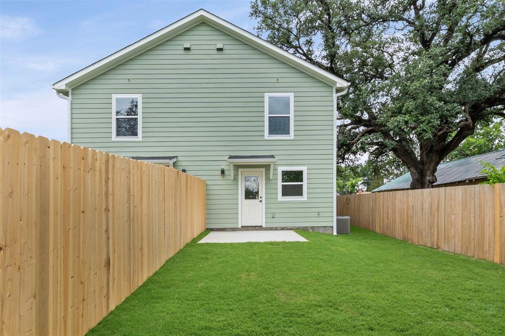 1536 Alexander Avenue, Unit A & B Waco, TX 76708 - Photo 7 of 30 Expansive fenced backyard featuring a concrete patio, green lawn, and light green horizontal siding on the home's exterior