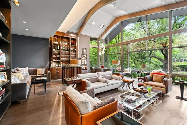 a living room with furniture a rug and a floor to ceiling window