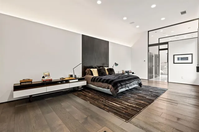 a bedroom with a bed and wooden floor