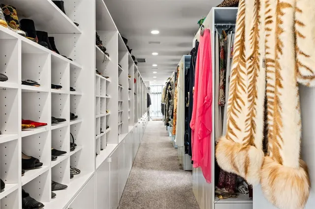 a view of walk in closet with clothes and shoes
