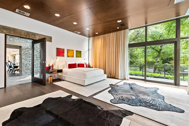 a bedroom with a bed and large windows