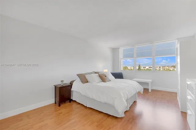 a bathroom with a bathtub shower sink mirror and toilet