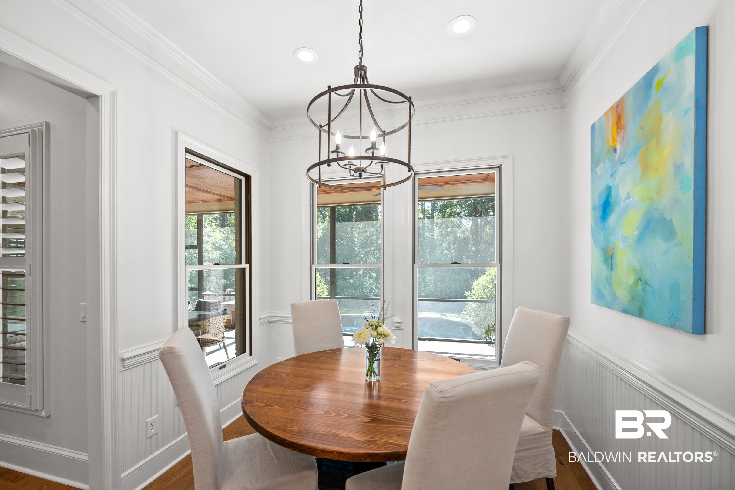 115 Sandy Ford Road Fairhope, AL 36532 - Photo 15 of 47 Dining area with a chandelier, wood finished floors, a wainscoted wall, ornamental molding, and a decorative wall