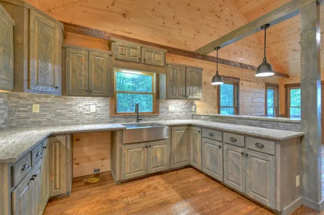 a view of an empty room with wooden floor fireplace and a window