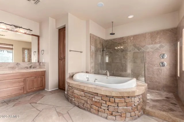 a spacious bathroom with a granite countertop sink a mirror and a shower