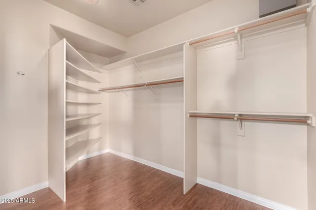 an empty room with closet and a ceiling fan