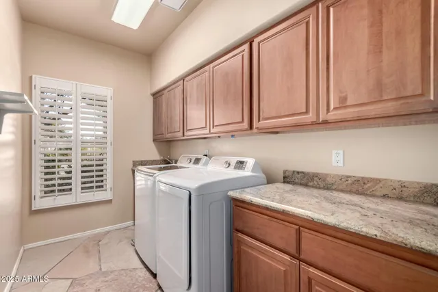 a view of an empty room with a window and kitchen view