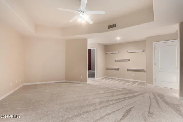 a view of an empty room with closet and a chandelier fan