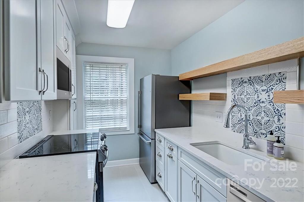 104 Colville Road, Unit 41C Charlotte, NC 28207 - Photo 5 of 22 a kitchen with stainless steel appliances granite countertop a sink stove and refrigerator