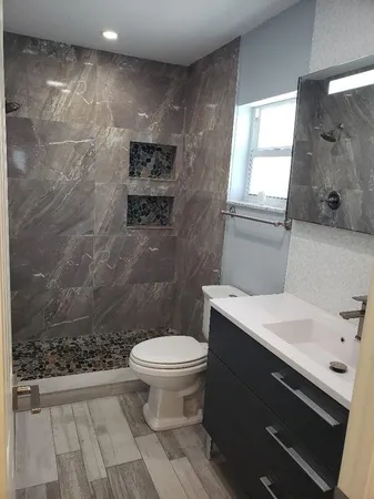 a bathroom with a sink a toilet and a window