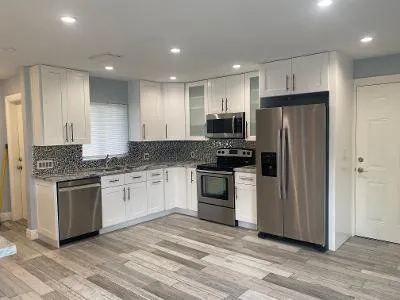 a kitchen with granite countertop a refrigerator stove and sink