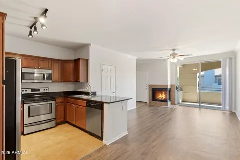 a kitchen with stainless steel appliances granite countertop a stove top oven a sink and a refrigerator