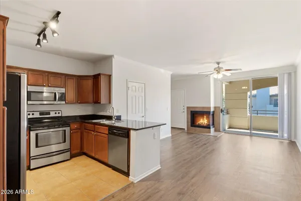 a kitchen with stainless steel appliances granite countertop a stove top oven a sink and a refrigerator
