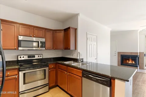 a kitchen with granite countertop a stove sink and microwave