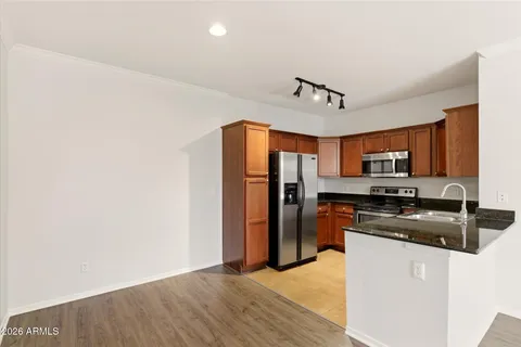a kitchen with stainless steel appliances granite countertop a refrigerator stove top oven and sink