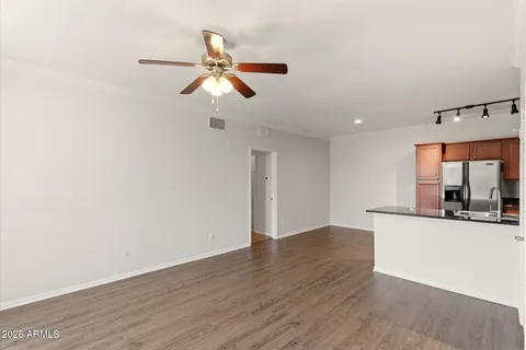 a view of a room with wooden floor and ceiling fan
