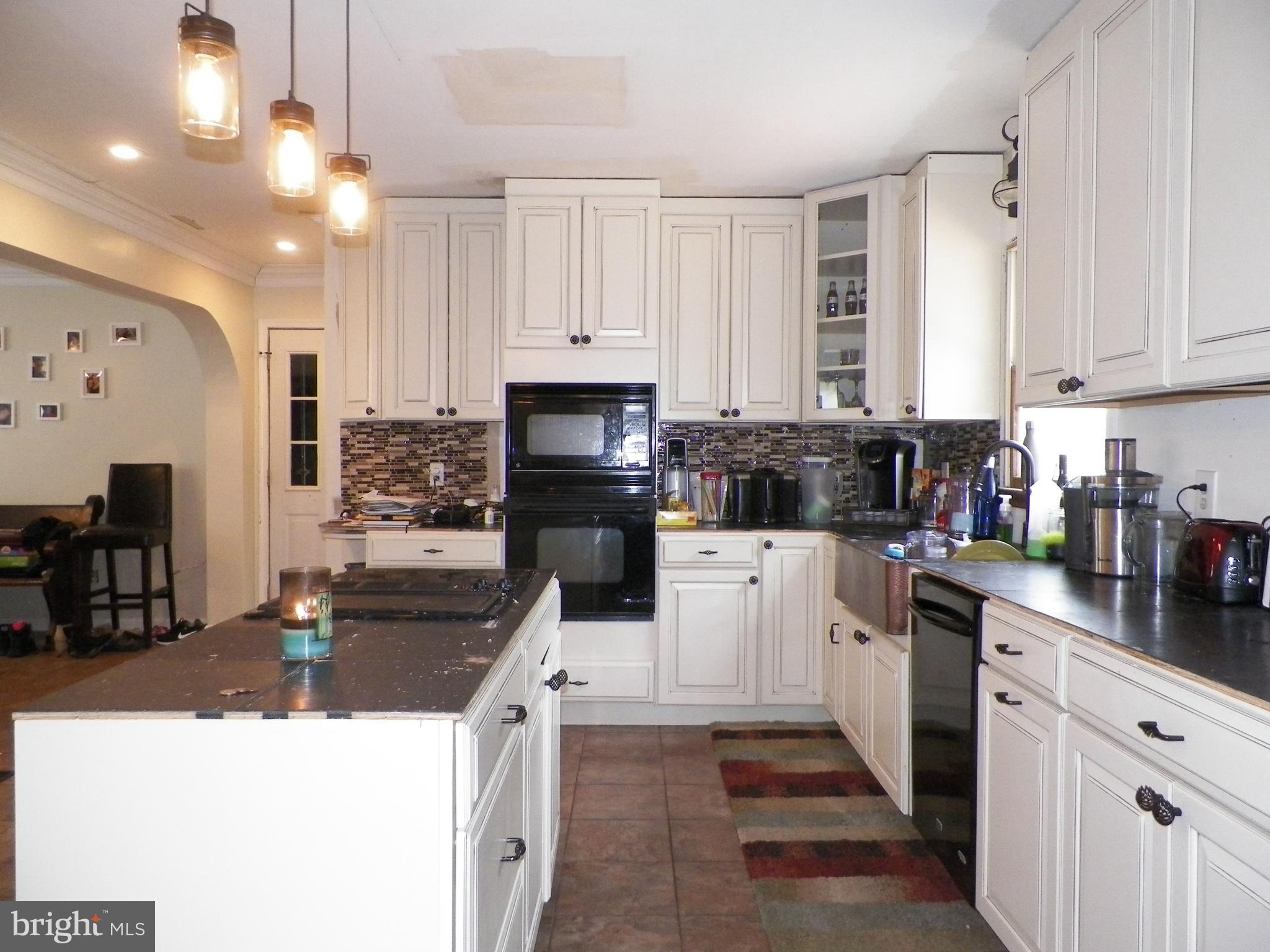 3151 Carroll Road Huntingtown, MD 20639 - Photo 15 of 30 a kitchen with stainless steel appliances kitchen island granite countertop a stove top oven a sink a refrigerator white cabinets and wooden floor