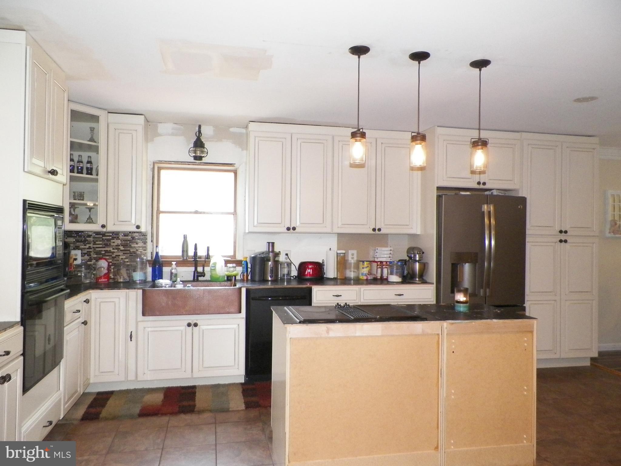 3151 Carroll Road Huntingtown, MD 20639 - Photo 7 of 30 a kitchen with stainless steel appliances granite countertop a refrigerator a sink a stove and white cabinets