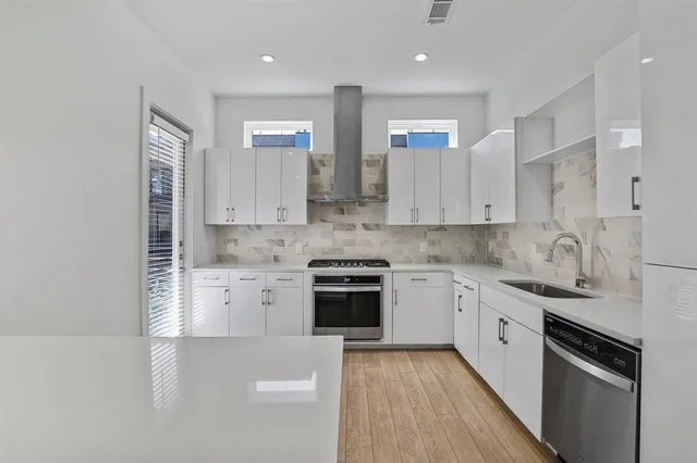a kitchen with granite countertop white cabinets and stainless steel appliances