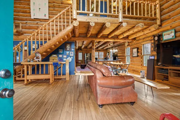 a sitting area with lots of furniture and wooden floor