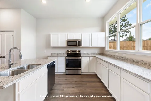 a kitchen with granite countertop a sink and a stove top oven